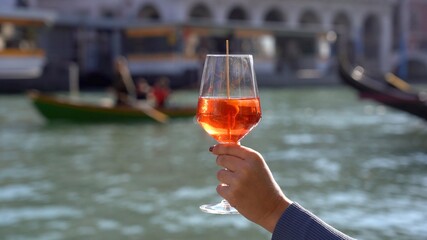 Girl holds in hand and drinks a glass of Spritz, in the city of love - aperitif, alcoholic drink...
