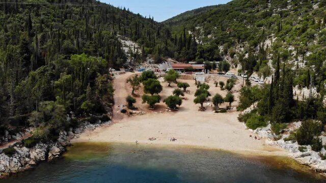 Restaurant Building Between The Green Forested  Mountain And The Sandy Seacoast In  Foki Beach, Greece. aerial