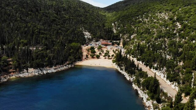 Restaurant Located In The Mountain Side Overlooking Foki Beach In Italy - aerial shot