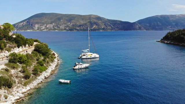 Cruise Ships Anchored At The Rocky Shore While The Tourists Are Exploring The Foki Beach In Greece.