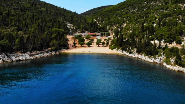 Foki Beach With Small Tavern, Lush Green Forest And Rocky Outcrops In Kefalonia, Greece. aerial