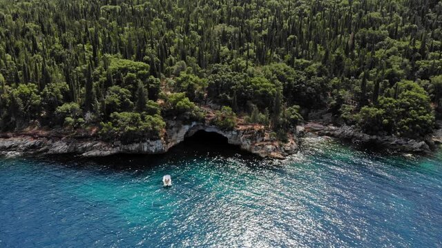 Aerial View Of A White Boat Near The Forested Seashore In Foki Beach, Kefalonia, Greece.