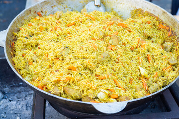ready-made pilaf in a cauldron. rice cooked with vegetables and meat. street food