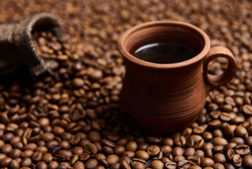 Close-up composition of a clay coffee cup with freshly brewed coffee drink with steam on the...