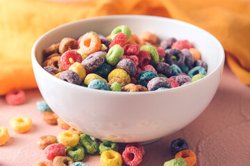 Bowl with crunchy corn flakes rings on color background
