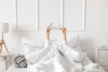 Morning of young woman lying in bed