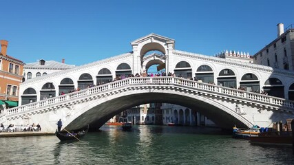 Europe, Italy, Venice November 2021 - Gondolas in Canal Grande with tourist and gondolier in Rialto bridge famous attraction in city of love 