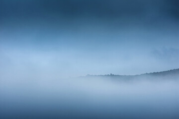 Mist covering an autumn forest in the morning.