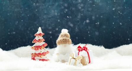 Funny gnome with Christmas decorations on a winter snowcovered background Xmas or New Year greeting card.