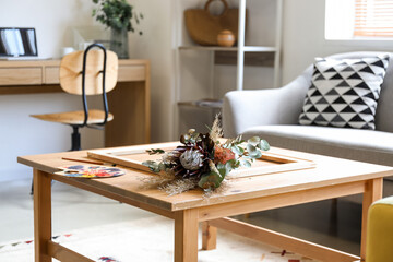 Beautiful bouquet of dried flowers on wooden table in living room