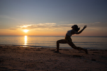 Crescent Lunge with Cactus Arms. Asian woman doing yoga poses on a beach in Koh Pha Ngan island, Thailand