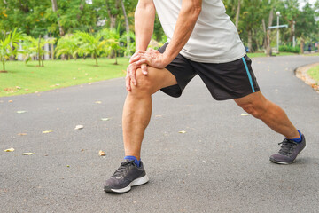an old man with legs muscle while warming up exercise before running or jogging. concept healthcare in elderly people