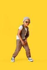 Cute dancing African-American boy on color background