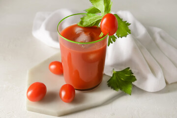 Board with glass of bloody mary on light background