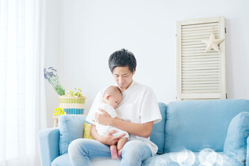 Obraz na płótnie Canvas 赤ちゃんを抱っこする父親