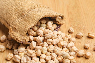 Dry chickpea in bag on wooden background.