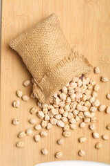 Dry chickpea in bag on wooden background.