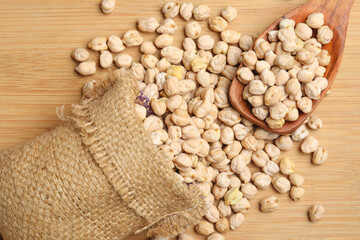 Dry chickpea in bag on wooden background.