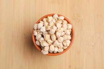 Dry chickpea in bowl on wooden background.
