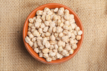 Dry chickpea in bowl on wooden background.