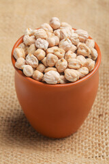 Dry chickpea in bowl on wooden background.