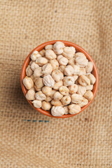 Dry chickpea in bowl on wooden background.