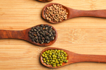 various dried types of bean and pea in wooden spoon.