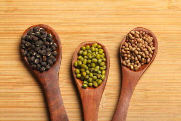 various dried types of bean and pea in wooden spoon.