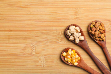 various dried types of bean and pea in wooden spoon.