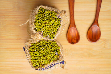 Green gram or mung bean in bag over wooden background.
