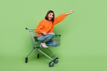 Photo of crazy lady pushcart rider put hand up superhero fly shopping center sales wear jumper isolated over green color background