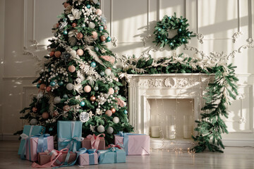 New Year's gifts in designer paper and bright ribbons under the Christmas tree on the floor on New Year's Eve. Christmas tree decorated with toys stands near the fireplace
