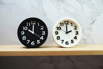 Clocks with time zone of different country on wooden shelves and marble background