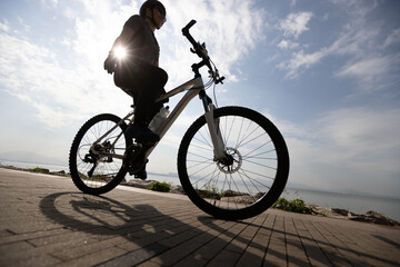 Fototapeta na wymiar Riding bike without holding the handlebar on the sunrise coast path