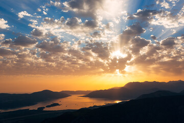 Orange sunset rays on the blue sky over the Bay of Kotor. View from Mount Lovcen