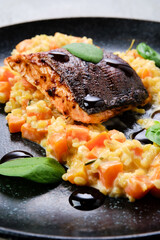 Closeup view of fried salmon steak served with bulgur and sweet potato
