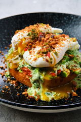 Closeup view of poached egg on a bun with avocado