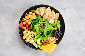 Top view of bowl with salad mix and various snacks