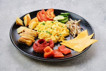 Scrambled eggs with various sausages, cheese, bell pepper and roasted onion