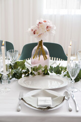 Beautiful table setting for wedding celebration with burning candles in restaurant
