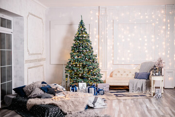 Warm cozy beautiful modern room design in gentle light colors decorated with a Christmas tree and decor elements for the new year