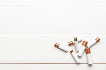 Alkaline batteries on white wooden background