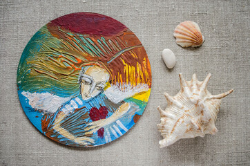 Angel with a heart in his hands painted in acrylic on a round board.