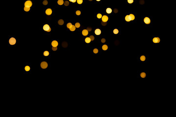 Bokeh golden lights background. Blurred Christmas garland lights on a black background