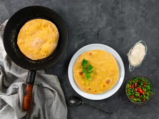 Homemade corn flatbread on frying pan cilantro green tomato salsa linen cloth. Handmade mexican tortilla vegetable. Traditional Indian Makki ki roti bread top view. Wheat flour dough authentic cuisine