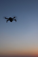 夕焼空を飛行するドローンの写真！マジックアワーの光