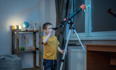 Fototapeta na wymiar Cute boy is looking through a telescope at the night starry sky. Children's scientific hobbies and space exploration