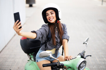  Beautiful woman getting ready for a ride on scooter. Beautiful happy lady taking selfie photo