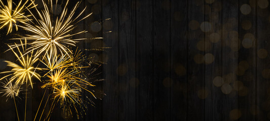 HAPPY NEW YEAR 2022 - Festive silvester firework background panorama greeting card banner long - Golden fireworks on dark black wood wall texture
