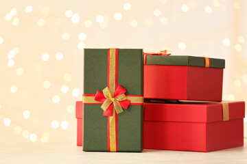 Christmas gift boxes on table against blurred lights